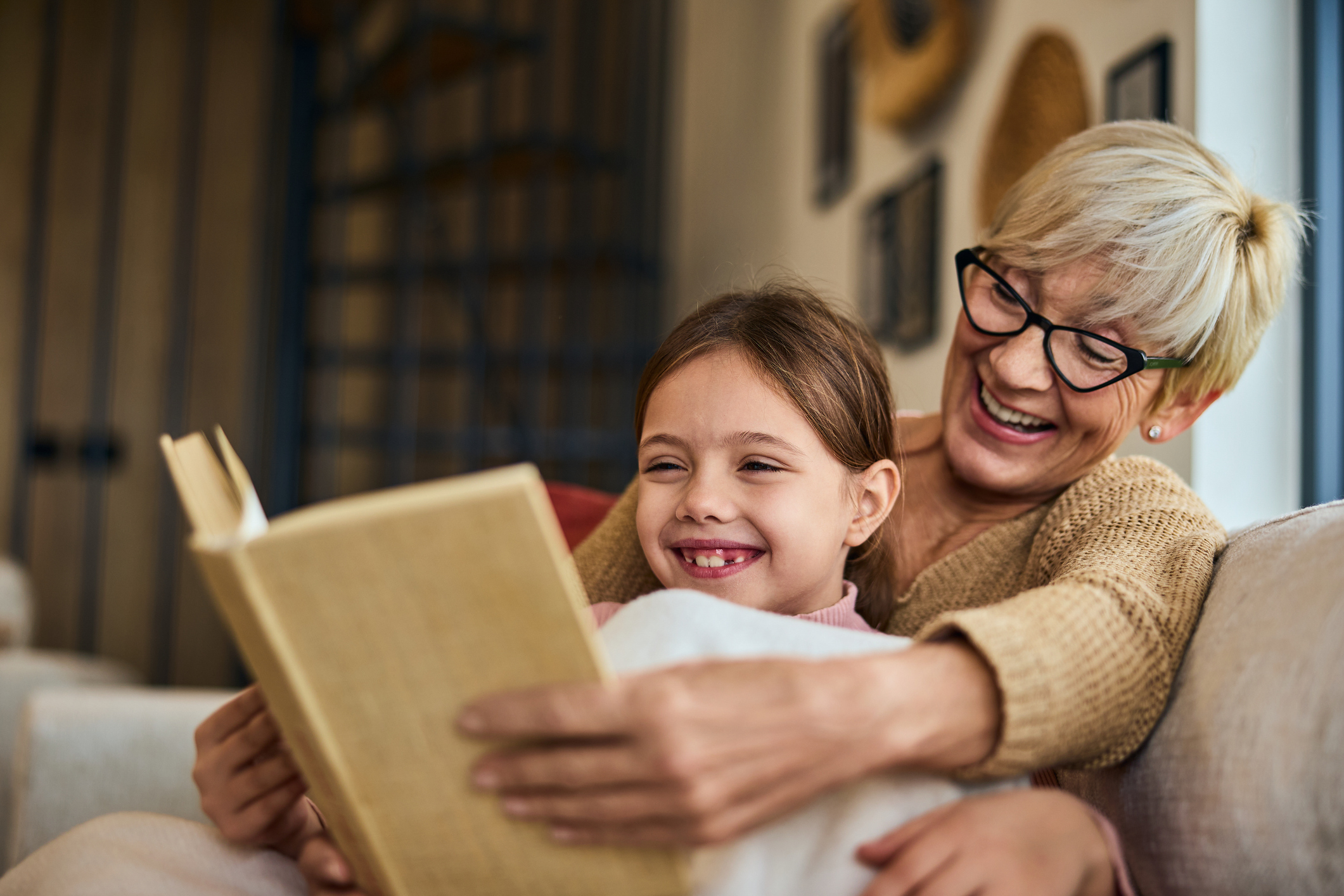 Grandmother and her grandchild reading a book together
